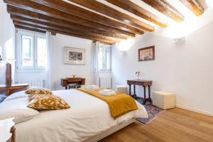 a bedroom with a large white bed and wooden ceilings at San Samuele Venezia Centro+ Wellness Pool Jacuzzi in Venice