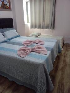 ヴィラ・ヴェーリャにあるApartamento De frente ao mar, linda varanda com churrasqueiraのベッドルームにタオル付きのベッド2台