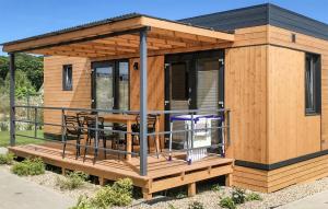 a wooden cabin with a table and chairs on a deck at Cozy Home In Rewal With Kitchen in Rewal