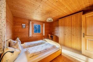 een slaapkamer met een bed in een houten kamer bij Thalhof Laugen in Ultimo