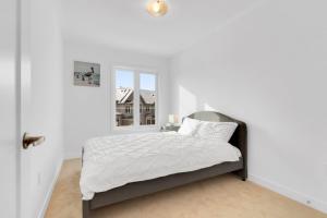 um quarto branco com uma cama e uma janela em Family Friendly Spacious Getaway em East Gwillimbury