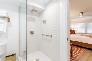 uma cabina de duche em vidro numa casa de banho com uma cama em The Beach Club on Madison Avenue em Cape May