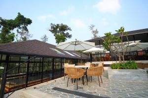 a patio with a table and chairs and umbrellas at Inika in Ponnampet