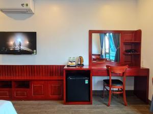Cette chambre comprend un bureau et un miroir. dans l'établissement glory 3 hotel 北宁格洛瑞3好酒店, à Bồ Sơn