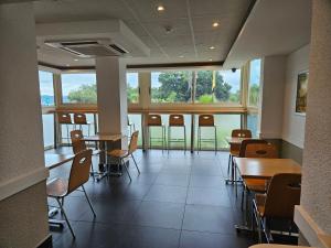 a dining room with tables and chairs and windows at SUN1 NELSPRUIT in Nelspruit +17 photos