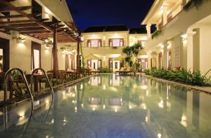 a swimming pool in front of a house at night at Green Boutique Villa in Hoi An