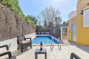 een zwembad met een tafel en stoelen naast een gebouw bij Orquidia by Rentallorca - Private pool and Garden in Port d'Alcudia