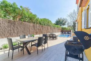 un patio con tavolo, sedie e griglia di Orquidia by Rentallorca - Private pool and Garden a Port d'Alcudia