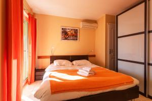 um quarto com uma cama laranja e toalhas em LA MALMAISON AP1064 Villefranche-sur-Mer, by RIVIERA HOLIDAY HOMES em Villefranche-sur-Mer