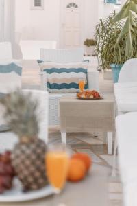 a living room with a table with plates of fruit at Dibellee Mykonos boutique studios in Glastros