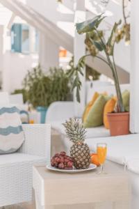 a plate with a pineapple and oranges on a table at Dibellee Mykonos boutique studios in Glastros