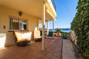 a patio with chairs and a view of the water at LA MALMAISON AP1064 Villefranche-sur-Mer, by RIVIERA HOLIDAY HOMES in Villefranche-sur-Mer