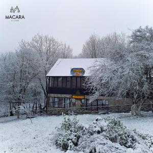 un edificio cubierto de nieve con un cartel. en Macara Lake Park, en Quba