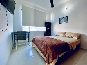 1 dormitorio con cama, escritorio y ventana en La palma- casa amoblada Palma Mayorca en Sincelejo