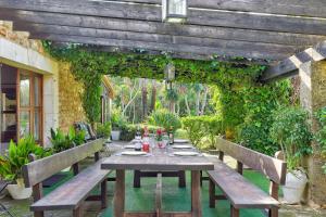 a wooden table sitting under a pergola at Finca Ranchon Grande by Rentallorca in El Port