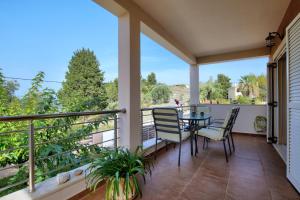 a patio with a table and chairs on a balcony at Cozy family home in Katouna in Katouna