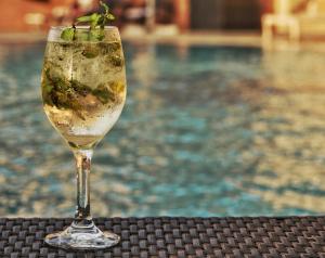 een wijnglas met een plant er naast een zwembad bij The Country Lodge Hotel in Freetown