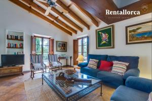 a living room with a blue couch and a table at Finca Son Guillotet by Rentallorca in Maria de la Salut