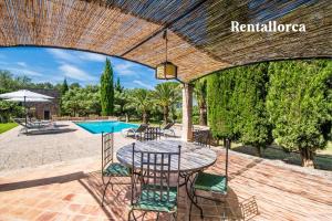 a patio with a table and chairs and a pool at Finca Son Guillotet by Rentallorca in Maria de la Salut