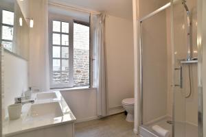 a bathroom with a sink and a toilet and a window at L'Escale Cancalaise - Maison de pêcheur 150m du port in Cancale +10 photos
