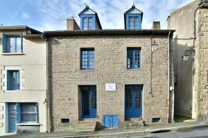 an old brick building with blue doors and windows at L'Escale Cancalaise - Maison de pêcheur 150m du port in Cancale