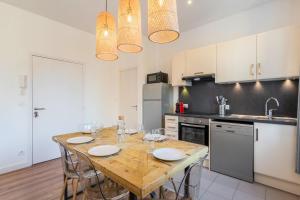 kuchnia z drewnianym stołem i krzesłami w pokoju w obiekcie Modern, quiet 3-bedroom apartment with parking w mieście Marcq-en-Barœul +26 zdjęć