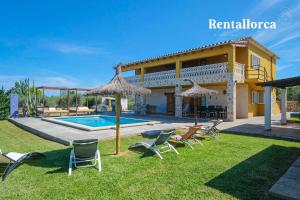 una villa con piscina, sedie e una casa di Cristi Bressals by Rentallorca a Alcudia