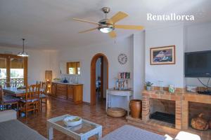 a living room with a ceiling fan and a fireplace at Cristi Bressals by Rentallorca in Alcudia