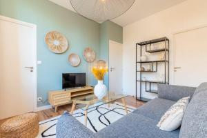 salon z kanapą i telewizorem w obiekcie Modern, quiet 3-bedroom apartment with parking w mieście Marcq-en-Barœul