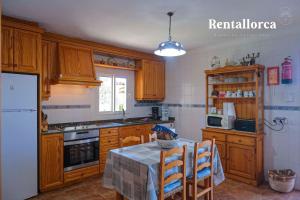 een keuken met een tafel en een witte koelkast bij Cristi Bressals by Rentallorca in Alcudia