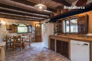 a kitchen with a refrigerator and a table at Finca Comteses Petit by Rentallorca in Alcudia