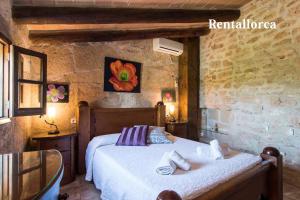 a bedroom with a bed in a stone wall at Finca Comteses Petit by Rentallorca in Alcudia