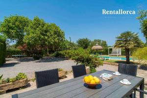 a wooden table with a bowl of fruit on it at Finca Comteses Petit by Rentallorca in Alcudia