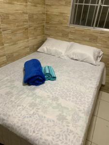 a bed with a blue bag on top of it at Quarto privativo Caruaru fácil acesso para o pátio de eventos e feira da sulanca in Caruaru