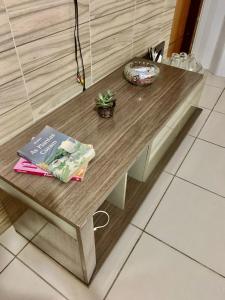a table with a book and a plant on it at Quarto privativo Caruaru fácil acesso para o pátio de eventos e feira da sulanca in Caruaru
