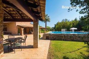 un patio con mesa y sillas junto a una piscina en Finca Ses Contesas by Rentallorca, en Alcudia