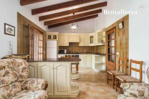 una cocina con armarios blancos y una isla. en Finca Ses Contesas by Rentallorca, en Alcudia