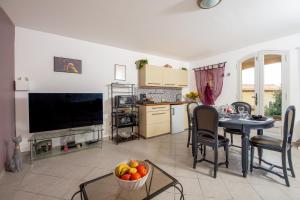 - une cuisine et un salon avec une table et un bol de fruits dans l'établissement La Joliette - Parking privé et piscine partagée, à Cabris