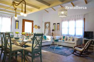 ein Wohnzimmer mit einem Tisch und einem Sofa in der Unterkunft Finca es Collet by Rentallorca in Manacor
