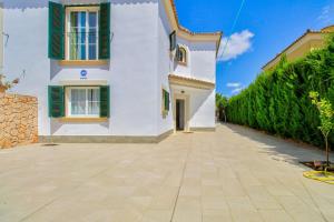 a white house with green shutters and a driveway at Can Caldero by Rentallorca in Llucmajor