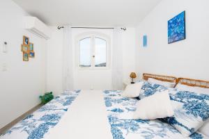 une chambre avec un lit avec des draps bleus et blancs dans l'établissement La Joliette - Parking privé et piscine partagée, à Cabris