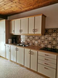 une cuisine avec des placards blancs et un comptoir dans l'établissement Apartments Steger Sand in Taufers Campo Tures, à Sand in Taufers