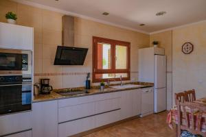 a kitchen with white cabinets and a sink and refrigerator at Finca Son Roca by Rentallorca in Montuiri