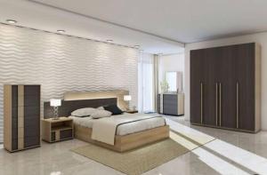 a bedroom with a large bed and a television at شقه حديثه علي النيل in Al Minya