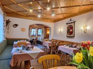 restauracja ze stołami, krzesłami i kwiatami w obiekcie Hotel Stegmühlhof w mieście Mauterndorf