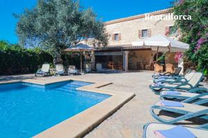 ブゲルにあるFinca Nyany by Rentallorcaの建物の隣にプール(椅子、パラソル付)