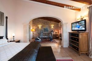 a bedroom with a bed and a flat screen tv at Finca Can Corem by Rentallorca in Manacor