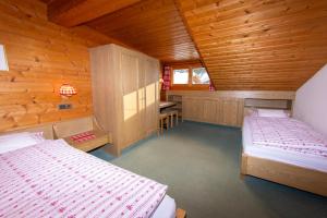 a bedroom with two beds in a wooden cabin at Appartment Lanz in Dobbiaco