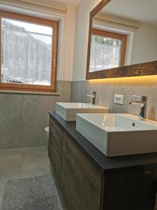 La salle de bains est pourvue d'un grand lavabo et d'un miroir. dans l'établissement Apartments Steger Sand in Taufers Campo Tures, à Sand in Taufers