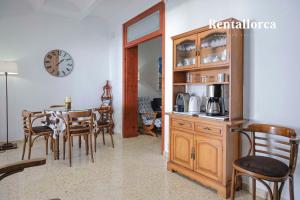 una sala da pranzo con tavolo, sedie e orologio di Casa Ca mado Josefa by Rentallorca a Santa Margarita
